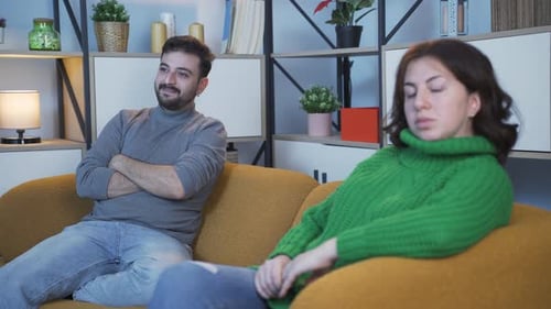 Man and Woman on Couch Having a Discussion