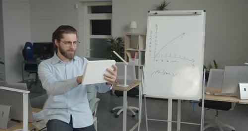 Man Presenting Via Tablet in Modern Office Setting