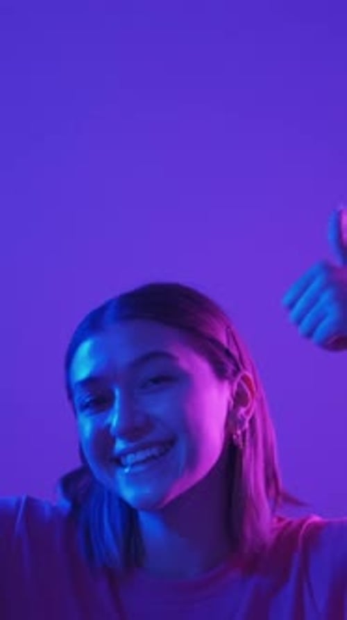 Smiling Girl Posing with Thumbs Up in Neon Light