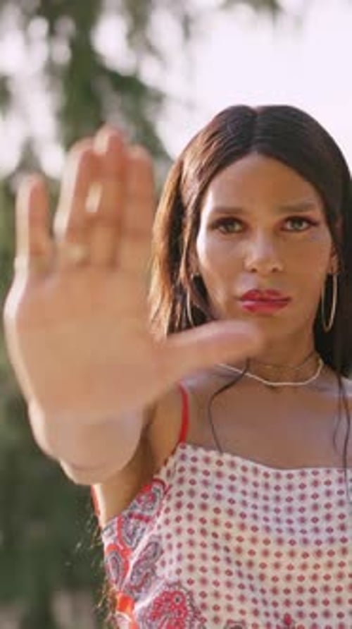 Mulher transexual estendendo a mão em sinal de parada