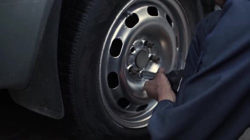 Mechanic Changes Tire on Vehicle with Drill