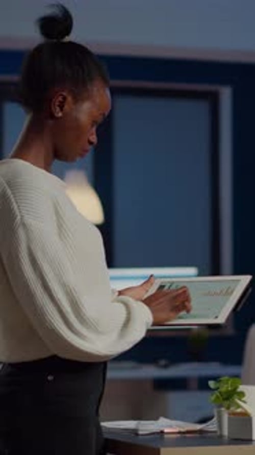 Black Woman Employee Standing in Office and Analysing Charts