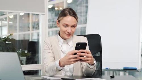 Confident Smiling Woman Using Mobile Phone App in Modern Light Office