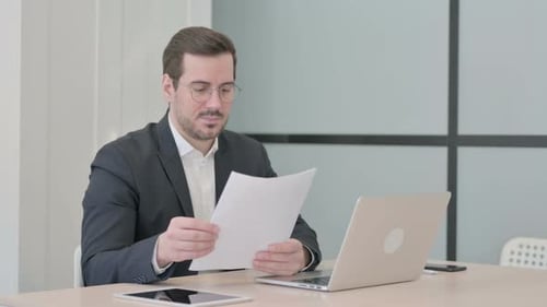 Man working at a desk with laptop and papers