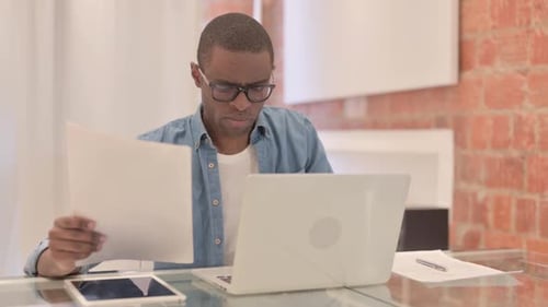 Young Man Working on Laptop at Home Office