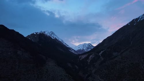 Mountain Slope Covered in Snow with Sunset in the Background