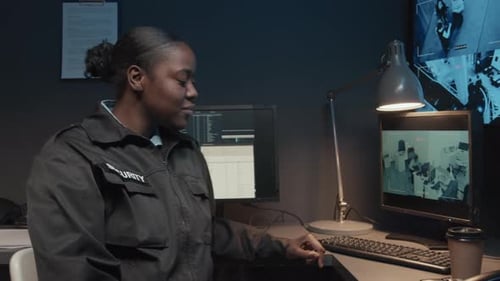 Smiling Security Guard Working at Computer Monitors