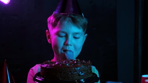 A Boy Bites a Chocolate Birthday Cake