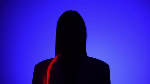 Une personne mystérieuse avec un effet de lumière bleu et rouge spectaculaire