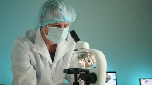 Medical Professional Using Microscope in Laboratory Setting