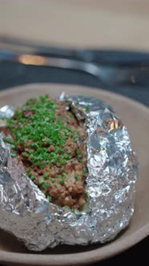 Baked Potato Topped with Herbs on a Plate