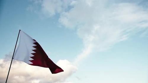 Qatar Flag Waving Proudly Against Cloudy Sky