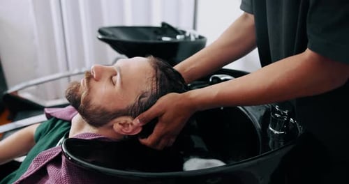 Man Having Hair Washed at a Barbershop