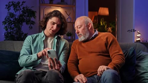 Young Adult and Senior Man Video Chatting at Home