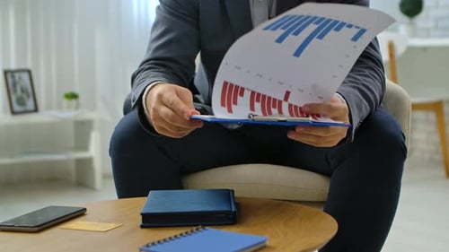 Business Professional Analyzing Financial Charts in Office Setting