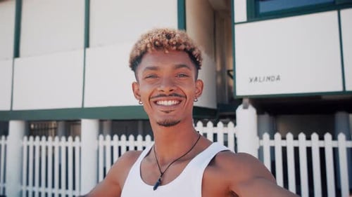 Smiling Young Man Waving Hand in Urban Setting
