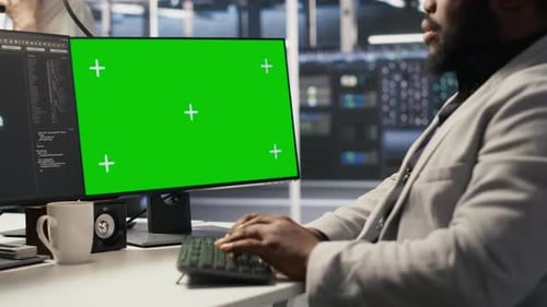 Rechenzentrumsadministrator überprüft Ausrüstung mithilfe eines Greenscreen-Mockup-PCs