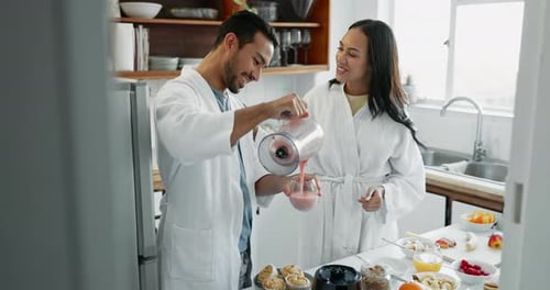 Couple in Bathrobes Making Smoothie in Kitchen