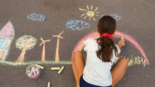 A Child Draws a Rainbow on the Pavement Selective Focus
