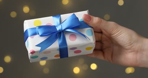 Festive Gift in Hand on Bokeh Background