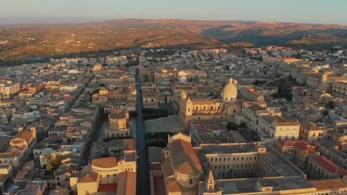 Aerial view of historic cityscape at sunrise, Italy.