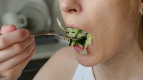 Close Up of a Young Woman Eating a Healthy Green Salad