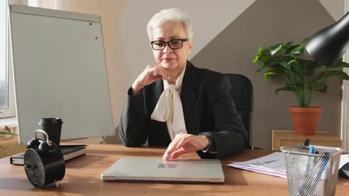 Woman Opens Laptop in Office at Desk