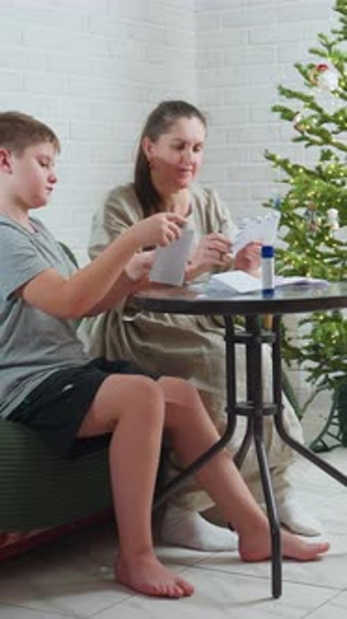 Teen and Woman Crafting Christmas Cards at Table