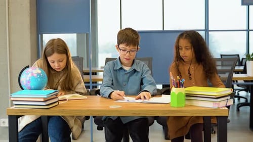 Gruppe verschiedener Schüler, die im Klassenzimmer studieren