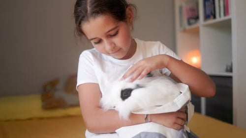Young Girl Cuddles Her Pet Rabbit
