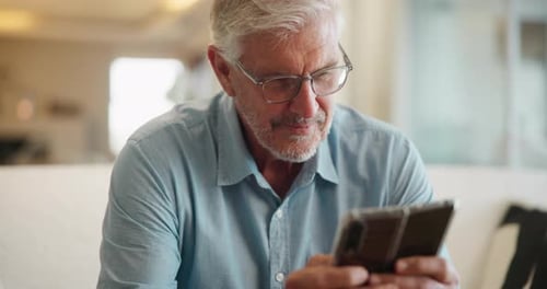 Senior Man Using Mobile Phone Indoors