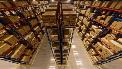 Un entrepôt bien organisé avec des boîtes soigneusement empilées disposées le long des allées