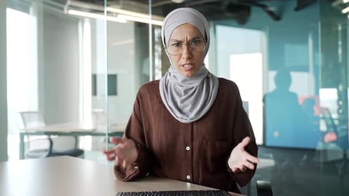 Webcam view of irritated arguing muslim businesswoman in hijab looking at camera yelling shouting