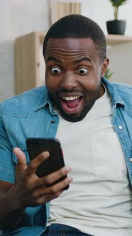 Excited man looking at his phone in disbelief