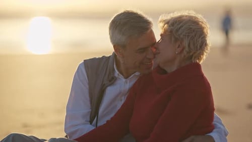 Senior Couple Sharing Intimate Moments at Sunset on Beach