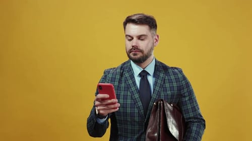 Smiling Businessman Looking at Mobile Phone