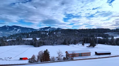 Few houses located in the field covered with snow.