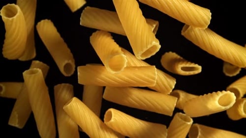 Studio shot of rigatoni pasta against black background