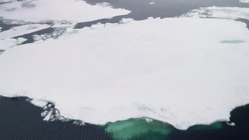 Aerial View of Fragmented Polar Sea Ice Drifting Floes and Dark Open Water Revealing Melting Pack