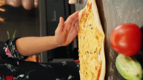 Taking out pizza from oven