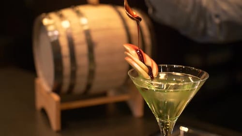 Bartender creates an elegant martini cocktail in slow motion at a modern bar