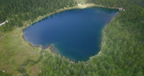 Aerial shot of an lake of mountains surrounded by nature in a magical, relaxing and green place.