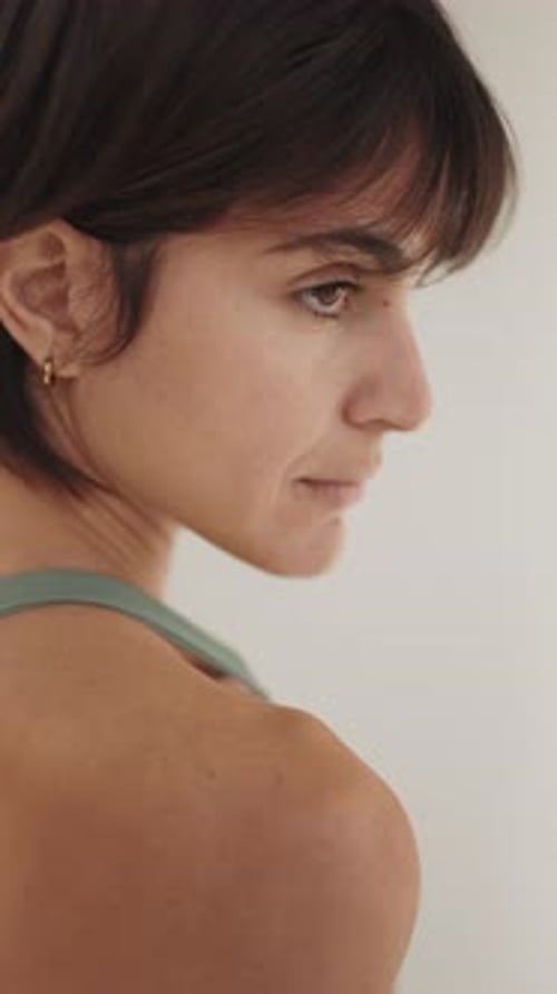 Young Woman in Activewear Stretching in Studio