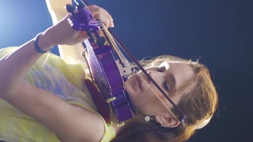 Woman Performing Violin in a Colorful Dress