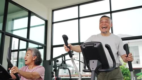 Active Senior Couple Exercising in Gym Together