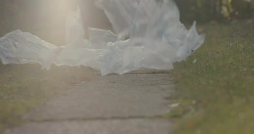 Imagen de
ángulo extremadamente bajo de residuos de envases que caen al suelo en el jardín o la naturaleza. Concepto corto para e