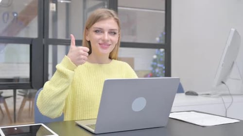 Woman at Desk Gives Thumbs Up