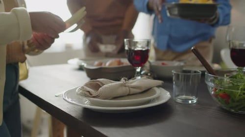 People Gather Around Table with Food and Wine