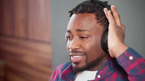 Man Enjoys Music with Headphones Indoors