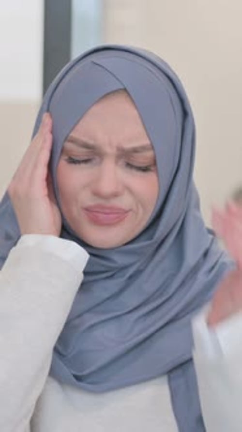 Young Woman Wearing Hijab Massaging Temples Experiencing Headache